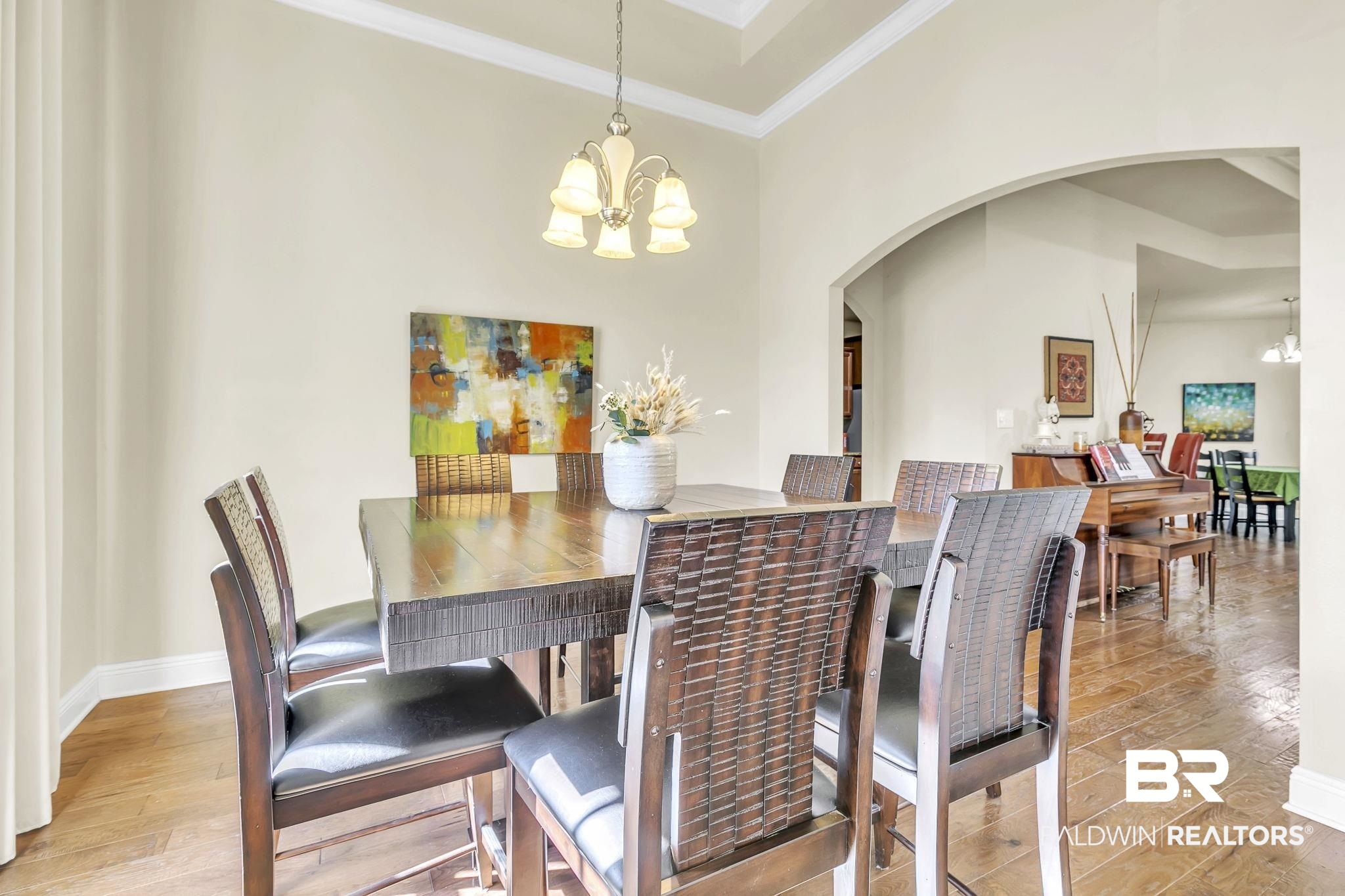 21439 Brick Stack Lane Fairhope, AL 36532 - Photo 7 of 32 Dining area with arched walkways, wood finished floors, and a notable chandelier