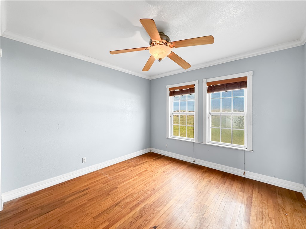 2977 Jurica Road Corpus Christi, TX 78415 - Photo 9 of 40 a view of an empty room with wooden floor and a window