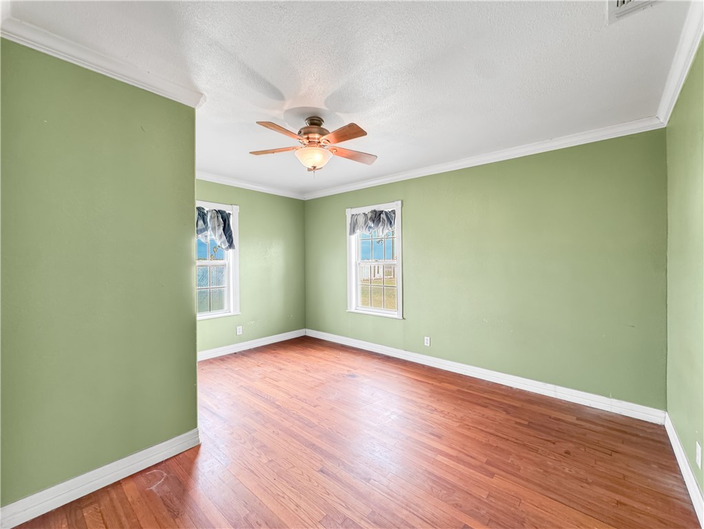 2977 Jurica Road Corpus Christi, TX 78415 - Photo 10 of 40 an empty room with a window and wooden floor