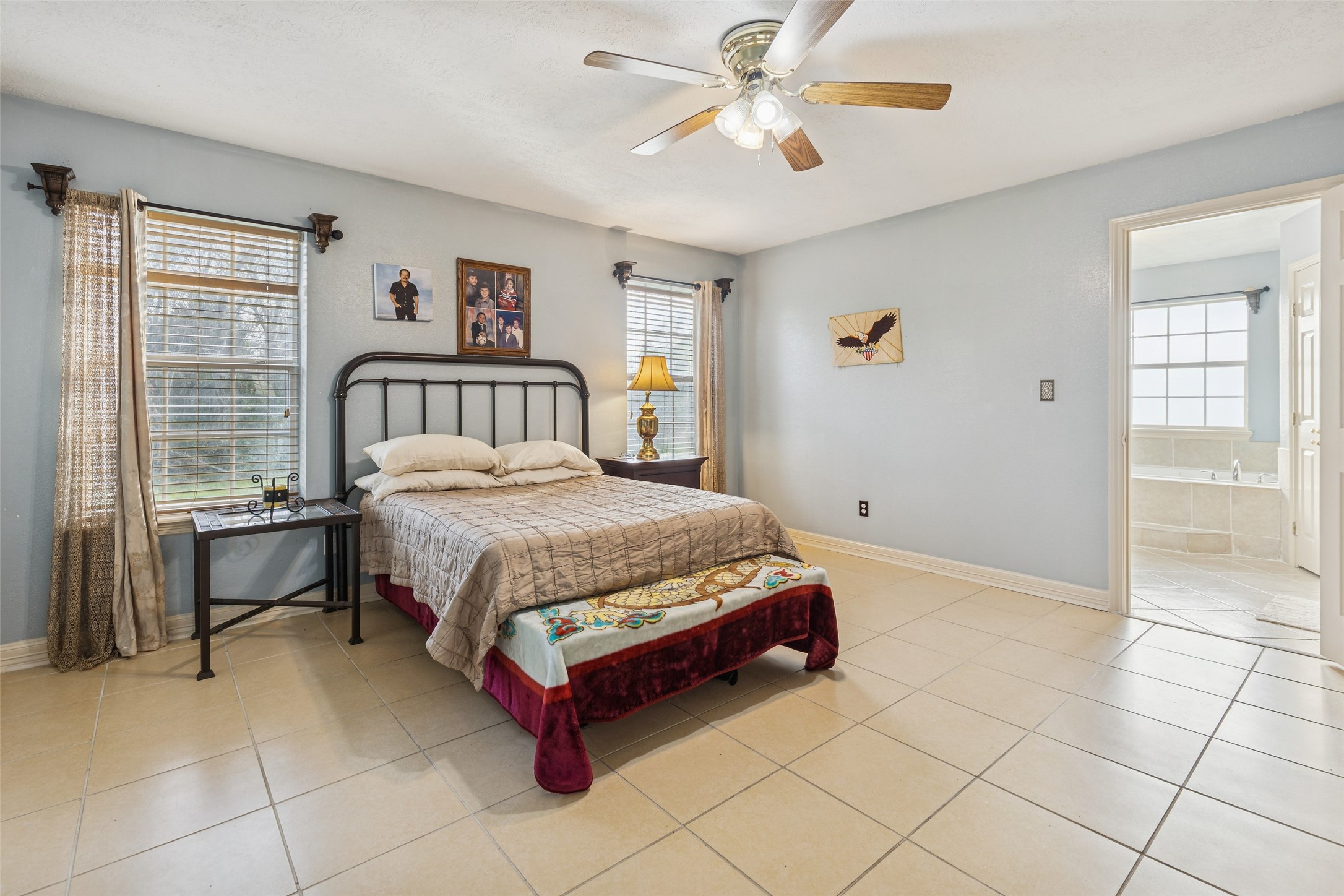 21 Pine Prairie School Road Huntsville, TX 77320 - Photo 16 of 26 a spacious bedroom with a bed and a chandelier