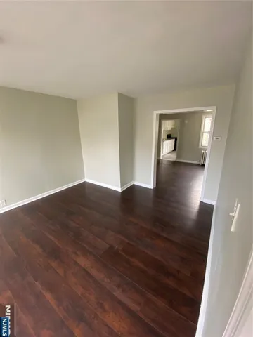 a view of a room with wooden floor and a bathroom