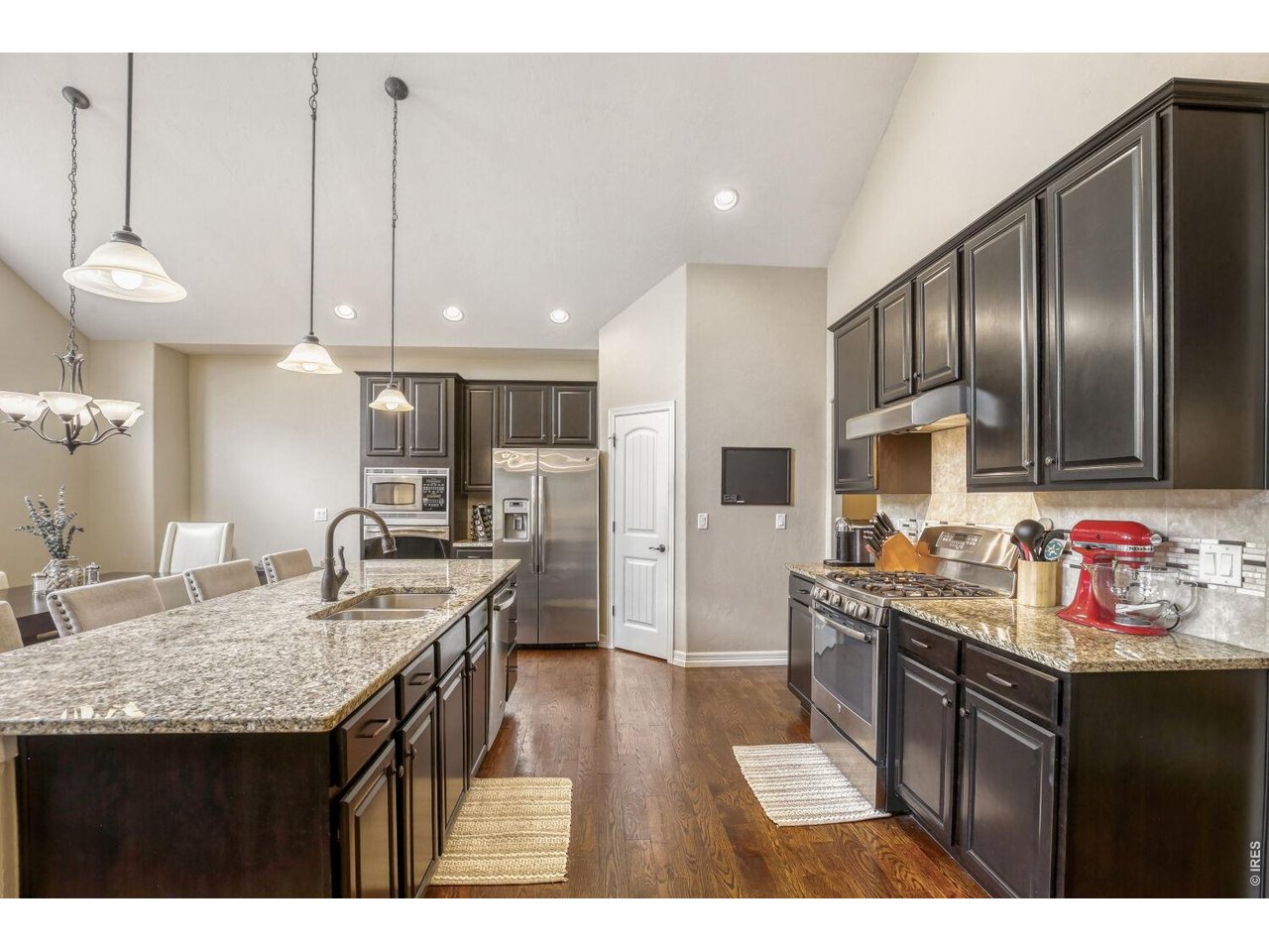 7992 St Street Frederick, CO 80530 - Photo 10 of 28 a kitchen with kitchen island granite countertop a sink stove and refrigerator
