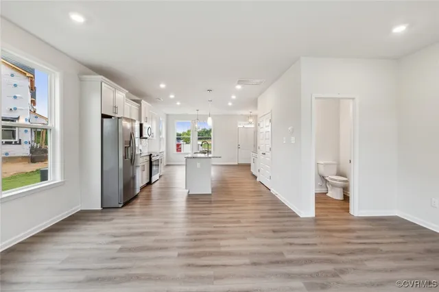 a view of a kitchen with a refrigerator and wooden floor