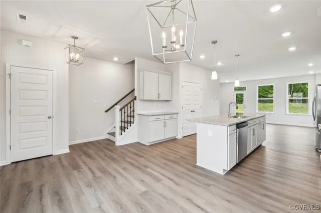 a open kitchen with kitchen island white cabinets and stainless steel appliances