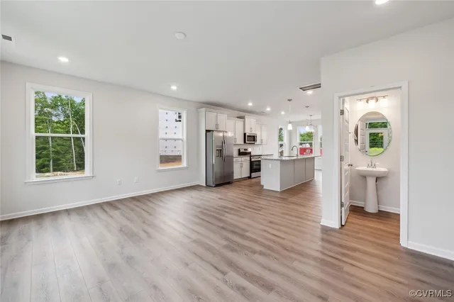 a view of a kitchen with a fridge wooden floor and a window