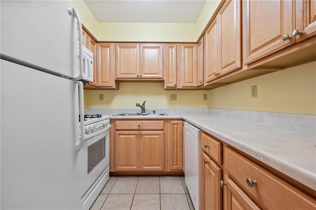 5 Bayard Road, Unit 221 Pittsburgh, PA 15213 - Photo 10 of 20 a kitchen with stainless steel appliances granite countertop a sink and dishwasher a refrigerator with white cabinets
