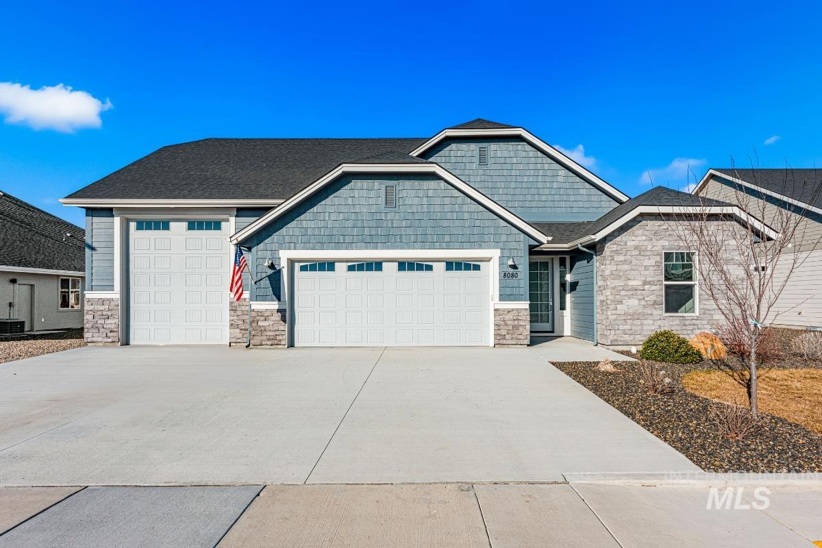 Craftsman inspired home with stone siding, concrete driveway, an attached garage, and a shingled roof