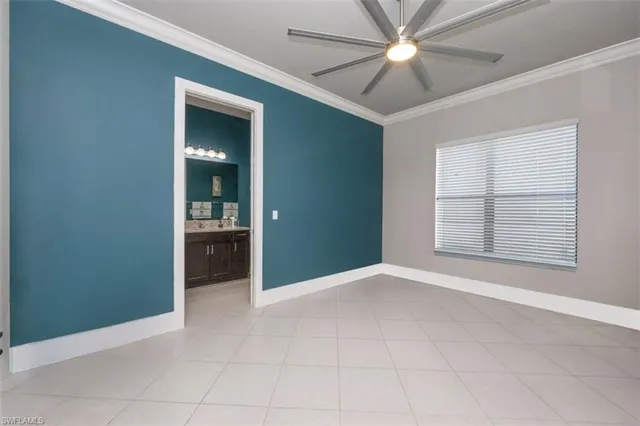 an empty room with chandelier fan and windows