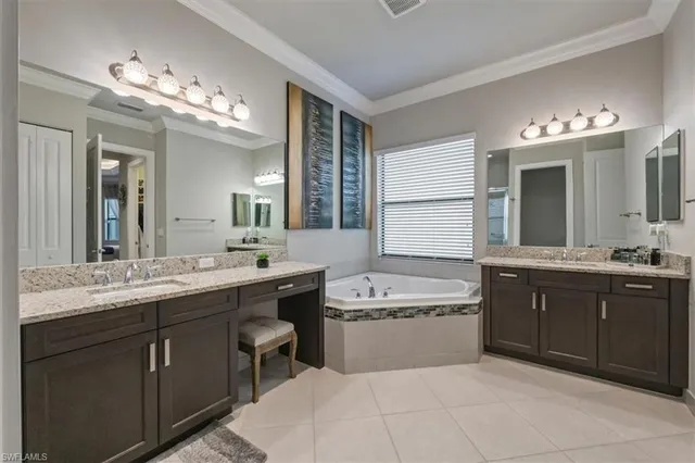 a spacious bathroom with a sink double vanity granite tub and a mirror