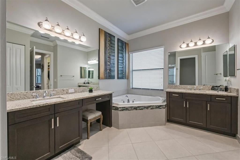 4172 Crescent Court Naples, FL 34119 - Photo 17 of 46 a spacious bathroom with a sink double vanity granite tub and a mirror