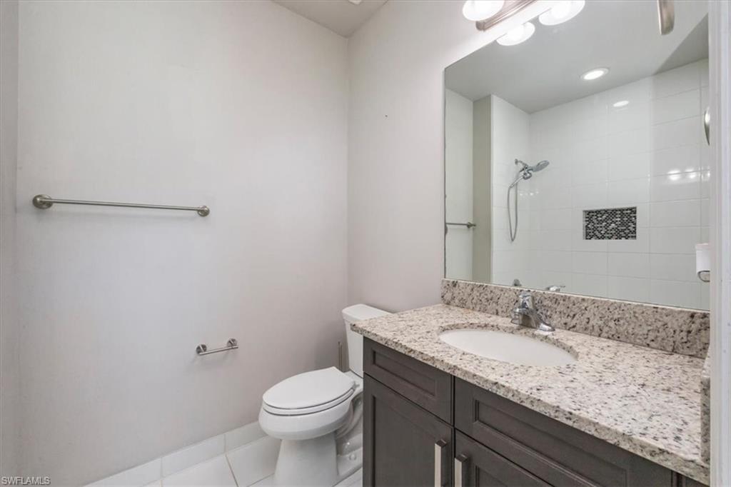 4172 Crescent Court Naples, FL 34119 - Photo 24 of 46 a bathroom with a granite countertop sink a toilet and a mirror