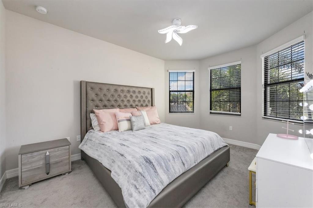 4172 Crescent Court Naples, FL 34119 - Photo 25 of 46 a bedroom with a large bed and a chandelier