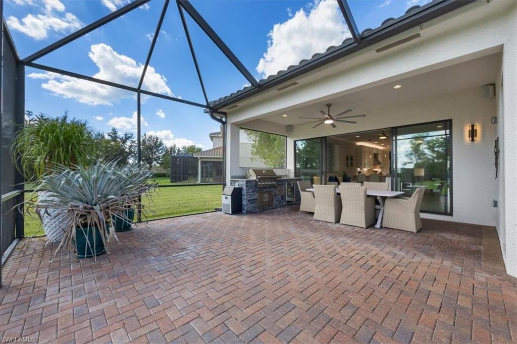 4172 Crescent Court Naples, FL 34119 - Photo 31 of 46 a view of a patio with table and chairs potted plants with wooden floor