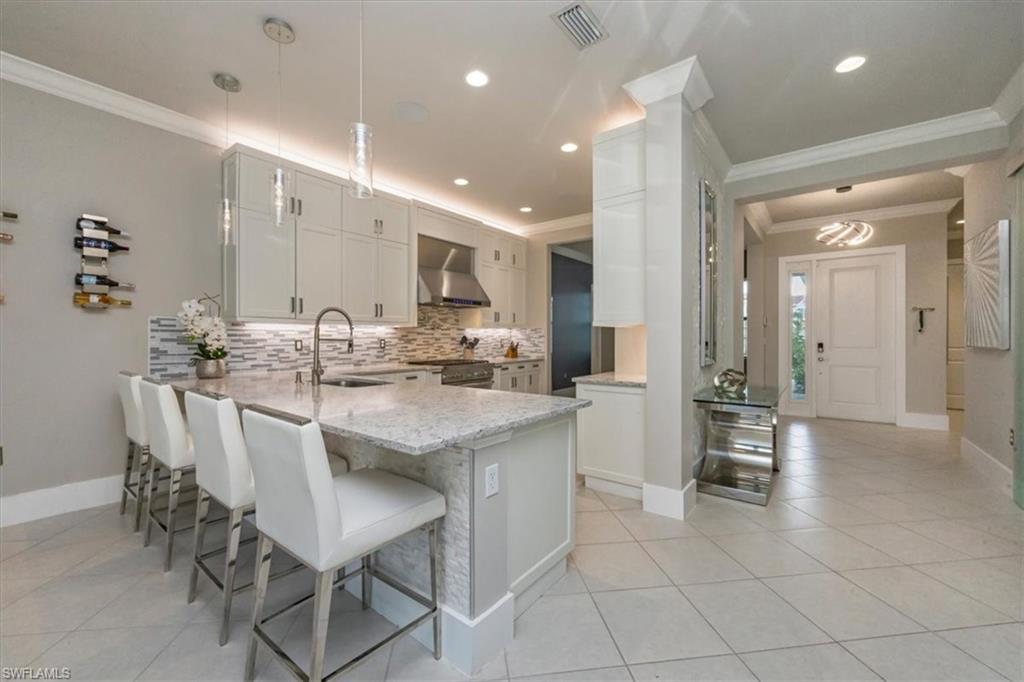 4172 Crescent Court Naples, FL 34119 - Photo 8 of 46 a kitchen with kitchen island granite countertop a sink and cabinets