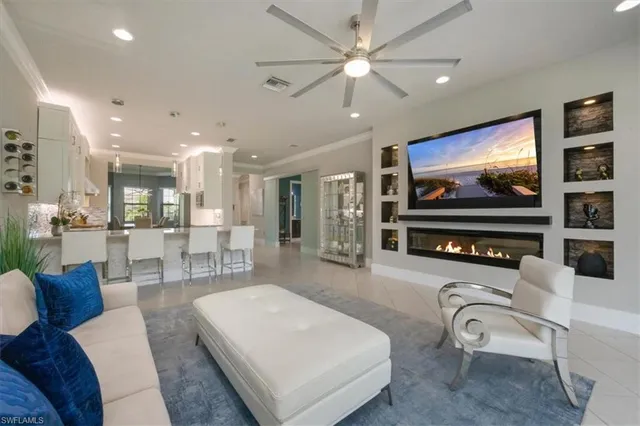 a living room with furniture a flat screen tv and kitchen view