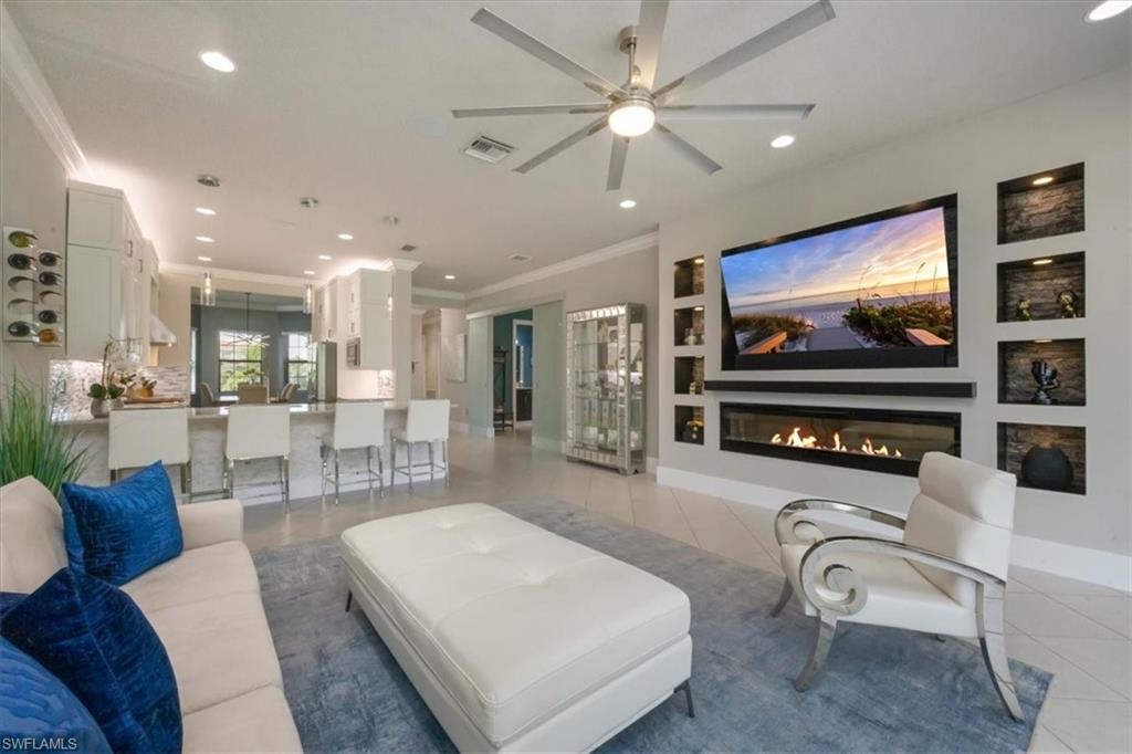 4172 Crescent Court Naples, FL 34119 - Photo 9 of 46 a living room with furniture a flat screen tv and kitchen view