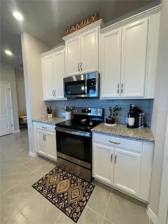 a kitchen with stainless steel appliances granite countertop a stove a sink and a microwave