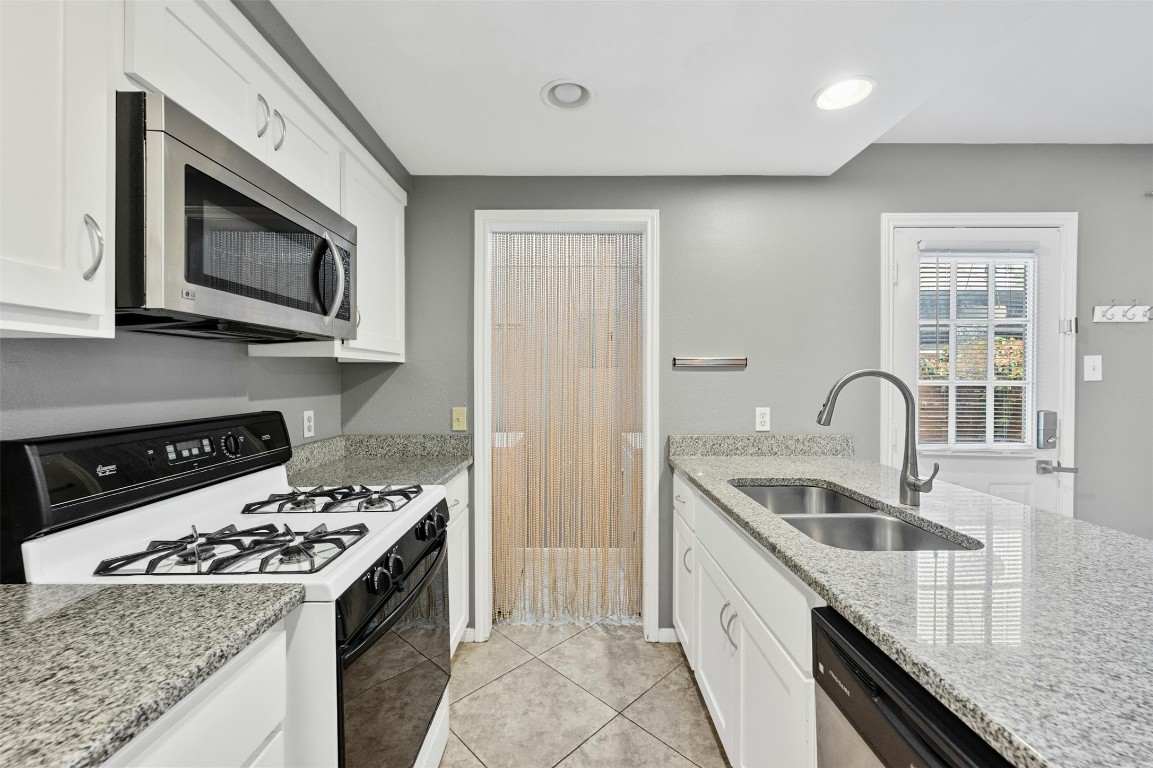 1904 Goodrich Avenue, Unit 4 Austin, TX 78704 - Photo 16 of 31 a kitchen with stainless steel appliances granite countertop a stove a sink and a microwave