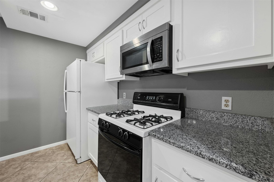 1904 Goodrich Avenue, Unit 4 Austin, TX 78704 - Photo 20 of 31 a kitchen with stainless steel appliances granite countertop a stove microwave and refrigerator
