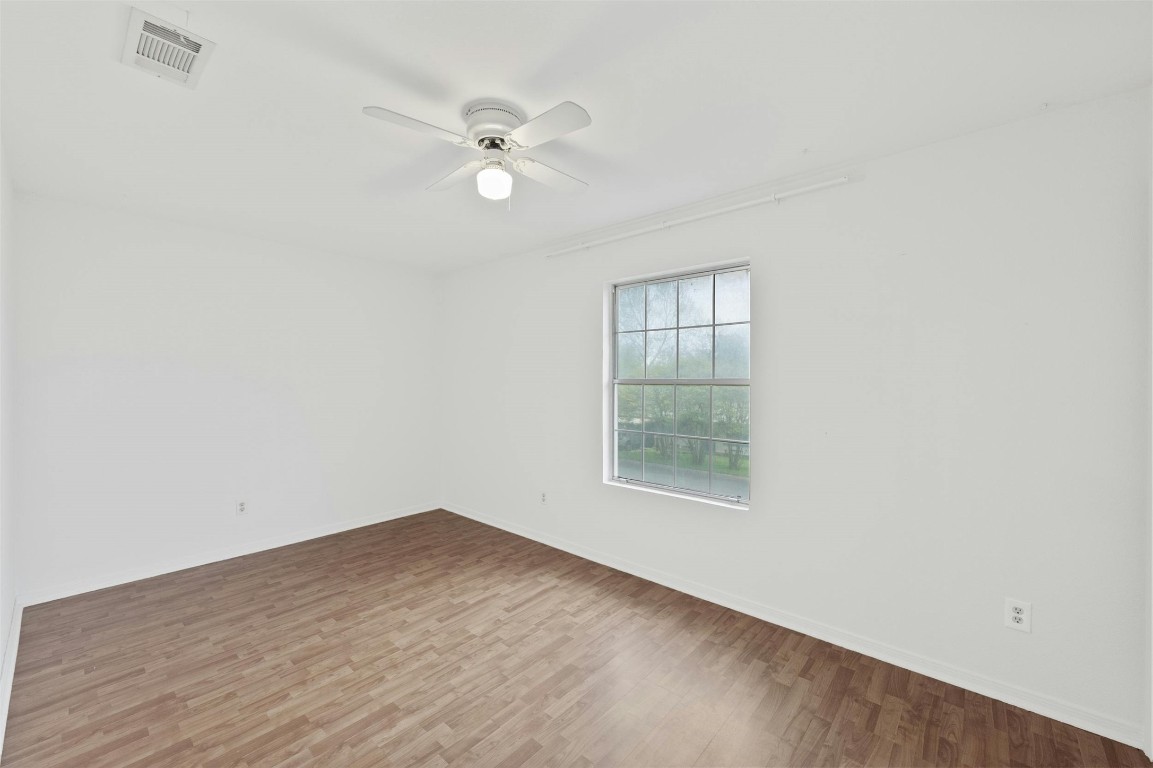 1904 Goodrich Avenue, Unit 4 Austin, TX 78704 - Photo 29 of 31 an empty room with wooden floor fan and windows