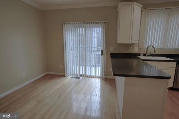 an empty room with wooden floor and cabinets