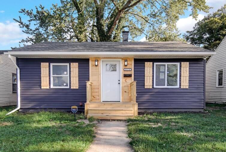 a front view of a house with a garden
