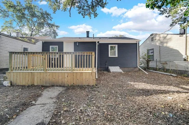 a view of a house with a yard and wooden fence