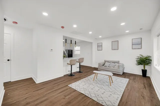 a living room with furniture and a wooden floor