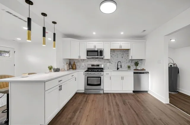 a kitchen with stainless steel appliances granite countertop a sink and stove top oven