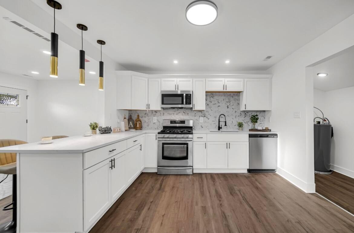 4514 East 10th Avenue Gary, IN 46403 - Photo 6 of 14 a kitchen with stainless steel appliances granite countertop a sink and stove top oven