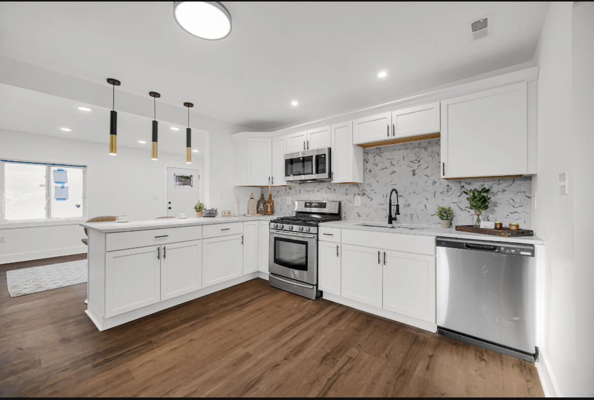 4514 East 10th Avenue Gary, IN 46403 - Photo 7 of 14 a kitchen with granite countertop white cabinets and white appliances