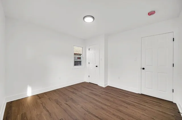 a view of a room with wooden floor and white walls