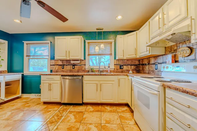 a kitchen with stainless steel appliances granite countertop a stove a sink and a refrigerator