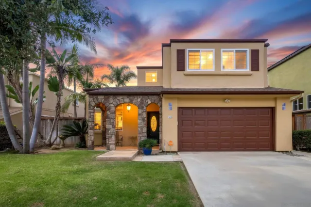 a view of a brick house with a large windows and a yard table and chairs