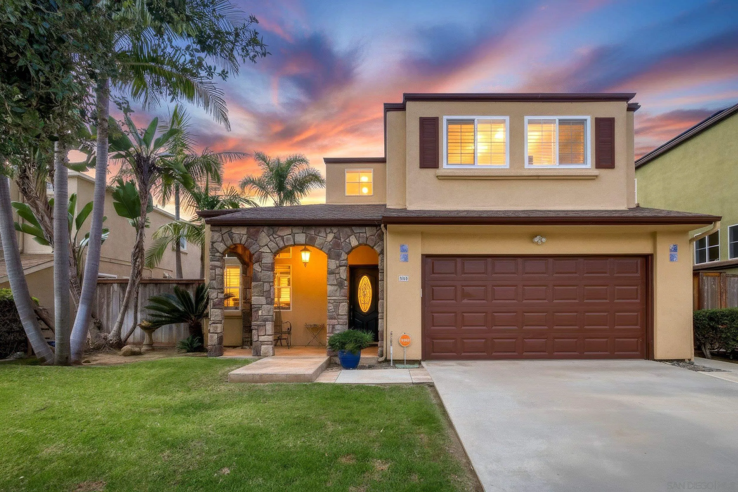 a view of a brick house with a large windows and a yard table and chairs