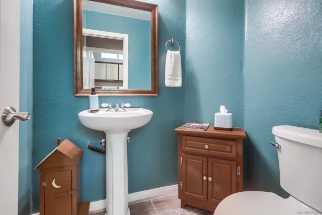 a bathroom with a toilet sink and mirror