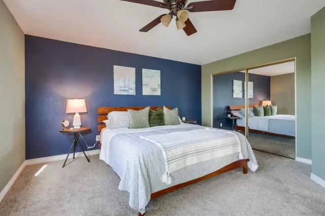 a spacious bedroom with a bed and dresser