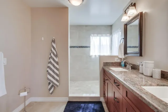 a bathroom with a granite countertop sink and a mirror