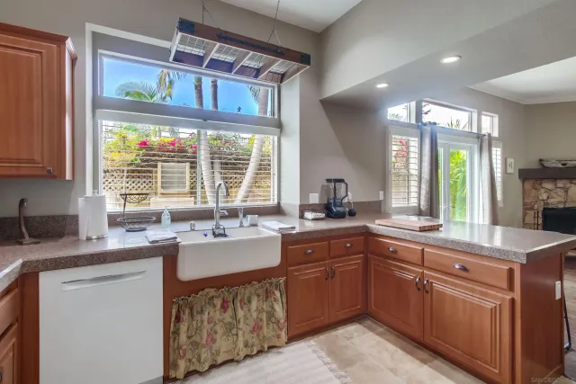 a kitchen with kitchen island granite countertop a sink stove and cabinets