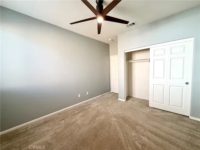 an empty room with closet and fan