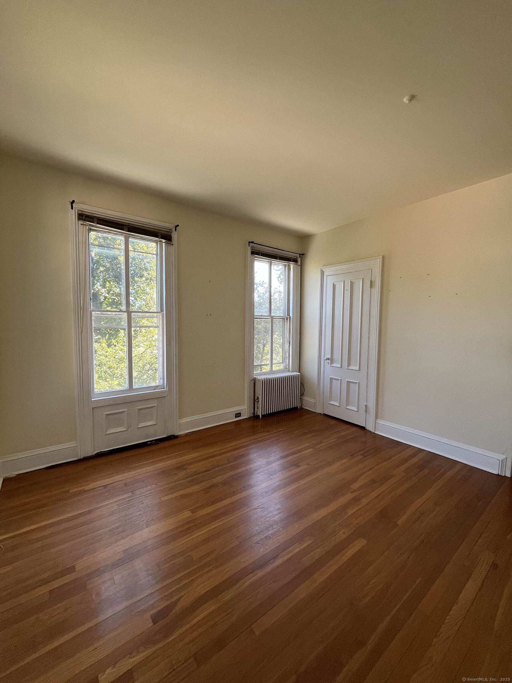 218 Flax Hill Road, Unit 4 Norwalk, CT 06854 - Photo 3 of 9 a view of an empty room with wooden floor and a window