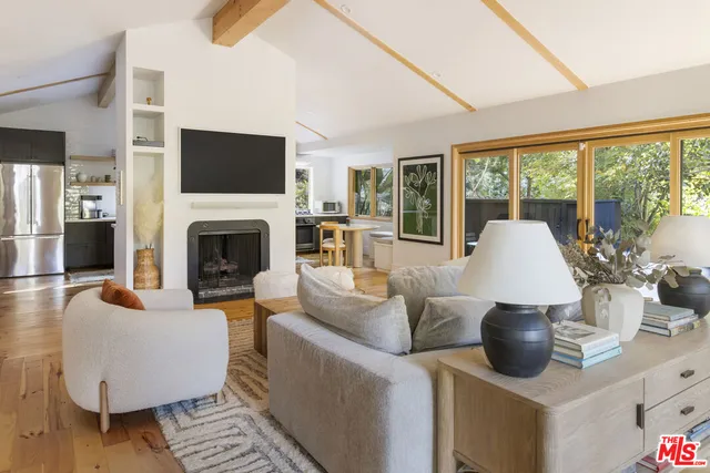 a living room with furniture a flat screen tv and a fireplace