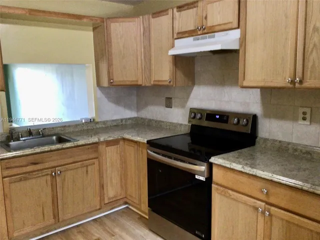 a kitchen with appliances cabinets and a counter top space