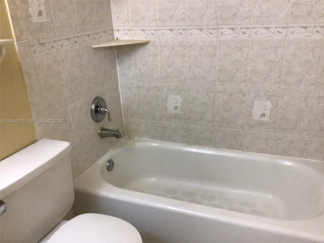 a white bath tub sitting next to a toilet