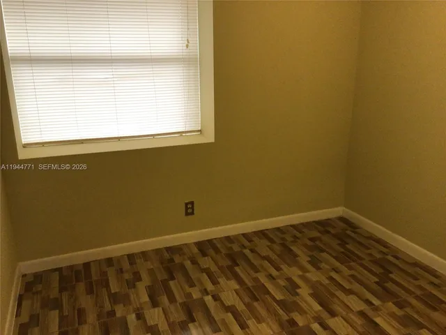 a view of a small space with wooden floor and a window