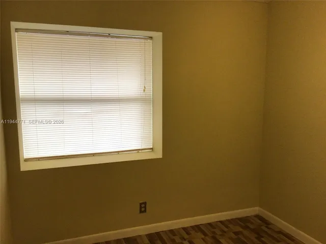 a view of a small space with wooden floor and a window