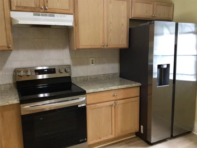 a kitchen with granite countertop white cabinets and black appliances
