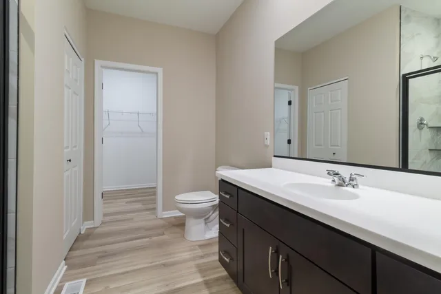 a bathroom with a sink a toilet and a mirror