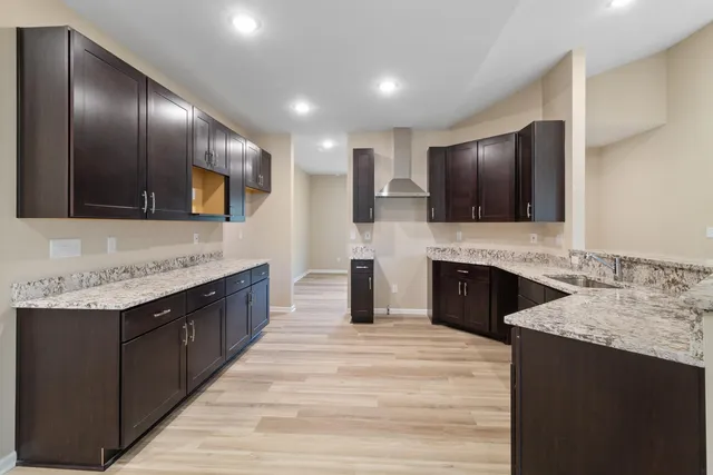 a large kitchen with granite countertop stainless steel appliances and a sink
