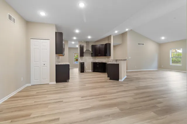 a view of kitchen and stainless steel appliances wooden floor